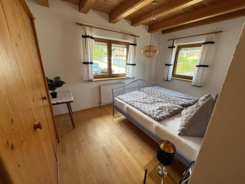 a bedroom with a bed and two windows at Ferienwohnung Volgger in Mils bei Hall