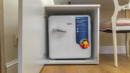 a white refrigerator in a room with a chair at Marita Hotel in Tbilisi City