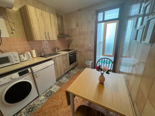 eine Küche mit einem Tisch mit einer Vase mit Blumen darauf in der Unterkunft Apartamento Teresa - Centro de Campillos in Campillos