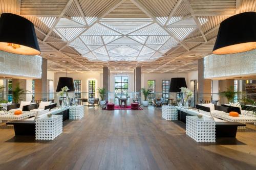 a lobby with couches and tables in a building at Pickalbatros Hôtel Du Golf - Adults Friendly 16 Years Plus- All-Inclusive in Marrakech