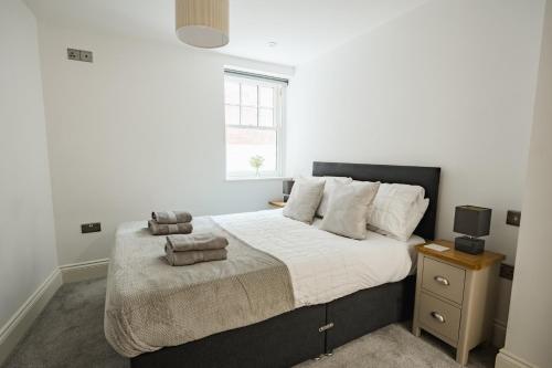una camera da letto con un letto con lenzuola bianche e una finestra di City Centre Luxury Spacious Apartment - Business & Leisure stays a Hull