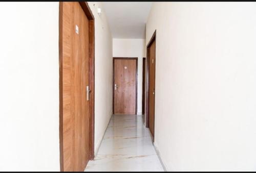 a hallway with white walls and wooden doors at Bluestone Residence in Pānchuria