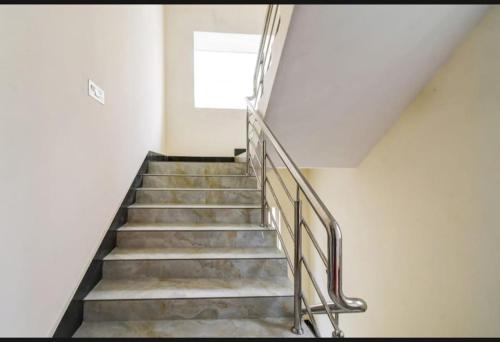a staircase with a metal railing and a window at Bluestone Residence in Pānchuria
