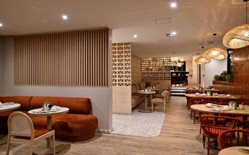 un restaurante con mesas, sofás y sillas en City Lodge Hotel V&A Waterfront, en Ciudad del Cabo