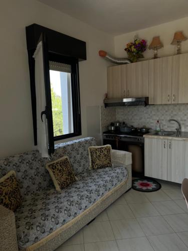 a living room with a couch and a kitchen at Holiday home in Vlorë