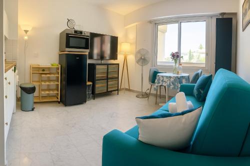 un salon avec un canapé bleu et une table dans l'établissement Studio Vue Mer, Piscine, 5 Mn Monaco Et Plages, à Roquebrune-Cap-Martin