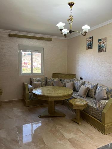 a living room with a couch and a table at PARADISE APARTments in Idoudouhane