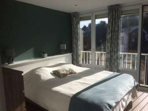 een slaapkamer met een bed en een groot raam bij L'estacade avec sur mer in Le Tréport