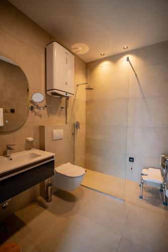 a bathroom with a toilet and a sink and a shower at Hotel Aria in Podgorica