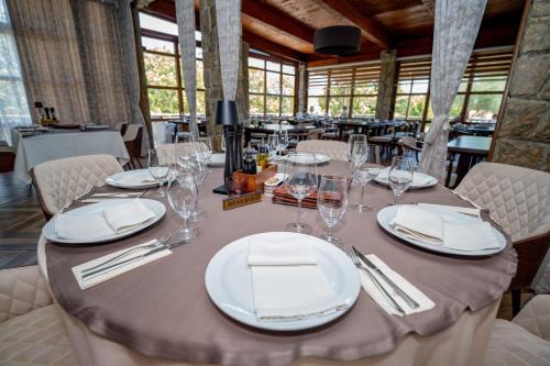 a table with white plates and glasses on it at Hotel Aria in Podgorica