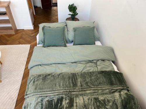 a bed with green sheets and pillows in a room at Pod Bimą in Tarnów