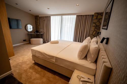 a bedroom with a large bed in a room at Hotel Aria in Podgorica