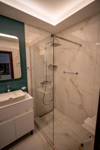 a bathroom with a shower and a sink at Hotel Aria in Podgorica