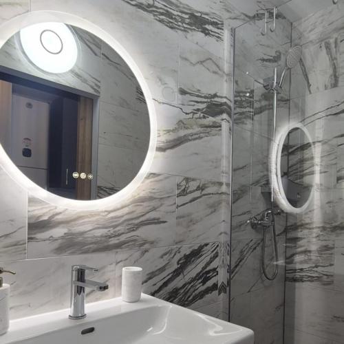 a bathroom with a sink and a mirror at Joli Studio Bord de Mer - Chic - Calme - Climatisé in Mauguio