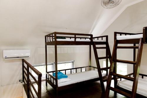 three bunk beds in a room with a window at Mantara Hostel in General Luna