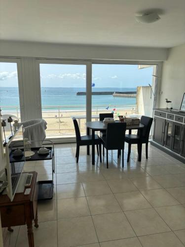 - un salon avec une table et une vue sur la plage dans l'établissement Apartment facing the large beach, à Quiberon