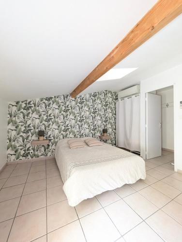 - une chambre avec un lit blanc et une fresque murale dans l'établissement Évasion vigneronne, jolie maison de village en pierre, à Vallon-Pont-dʼArc