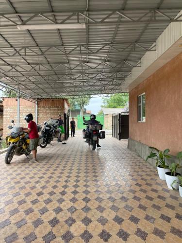 a group of motorcycles parked under a building at Shabdan Guest House in Toktogul
