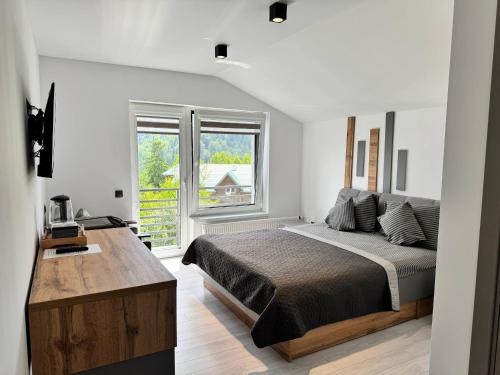 a bedroom with a bed and a large window at Chicago Hotel in Yaremche