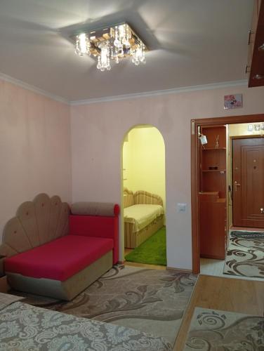 Una sala de estar con un sofá y un dormitorio. en Злуки47a район Бам, en Ternopilʼ