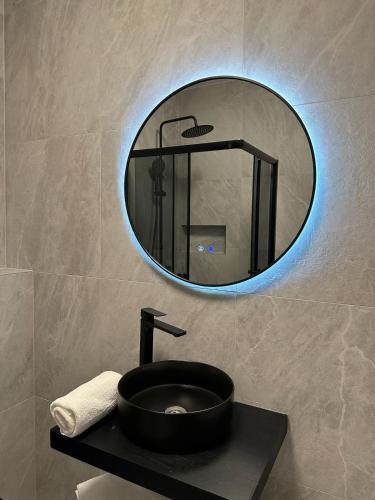 a bathroom with a black sink and a mirror at Pristina Luxury Apartments 45 in Pristina
