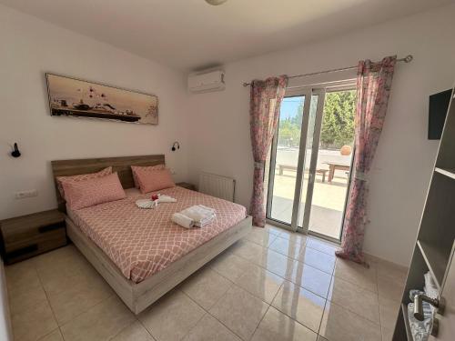 a bedroom with a bed and a large window at Treditto House - Ground Floor residence C1 in Koskinou