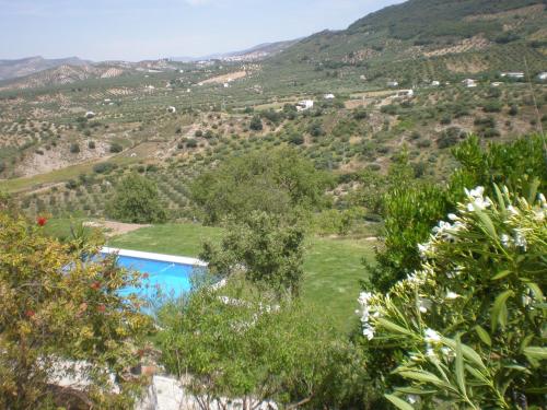 a view from the garden of a villa with a swimming pool in a mountain at Apartamentos Rurales El Cañuelo de Carcabuey in Carcabuey