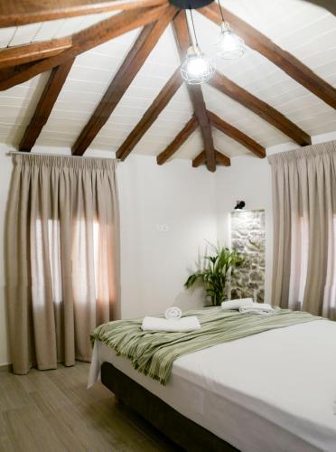 a bedroom with a bed in a room with wooden ceilings at Agnanti Studios in Roussopoúlion