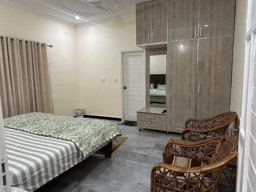 a bedroom with a bed and a dresser and a mirror at Luxurious 5 Bedroom Mansion Upper Portion Near Gerry Visa Park Road Islamabad in Islamabad