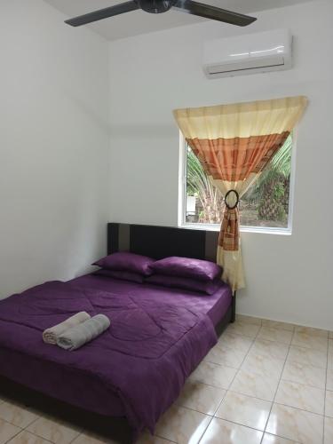 a bedroom with a purple bed and a window at AA Burger Homestay for Musliim Only in Banting