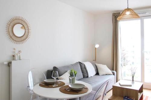 un salon avec un canapé et une table dans l'établissement Bright apartment in Saint-Ouen-sur-Seine, à Saint-Ouen