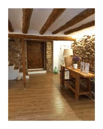 a living room with a table and a stone wall at Casa Morel in Morella