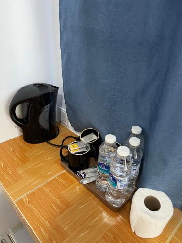 a table with bottles of water and a roll of toilet paper at Nu Melati Hotel in Pantai Cenang