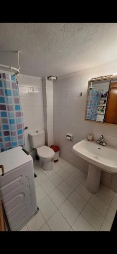 Un baño blanco con inodoro y lavabo. en The house by the sea, en Skála Foúrkas