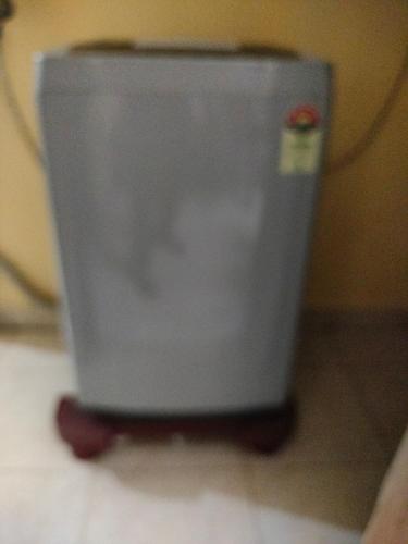 a gray trash can sitting on the floor at Dom's Inn in Mangalore