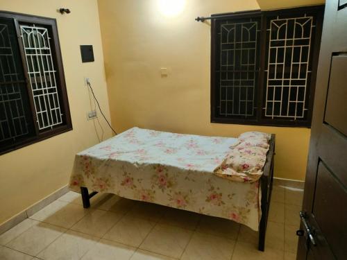 a small bed in a room with a table at Dom's Inn in Mangalore