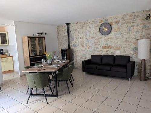 un salon avec une table et un canapé dans l'établissement Évasion vigneronne, jolie maison de village en pierre, à Vallon-Pont-dʼArc