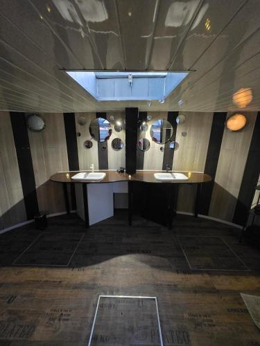 a bathroom with two sinks and a counter with mirrors at Péniche LOFT la campanella in Maizy