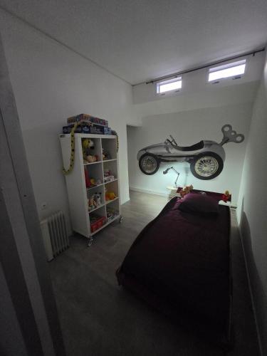 a bedroom with a motorcycle hanging on the wall at Péniche LOFT la campanella in Maizy