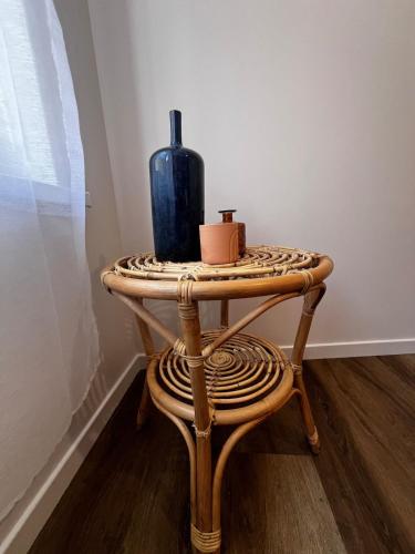 a table with a blue vase and two candles on it at Les Anges 1 - Hyper Centre in Cambrai