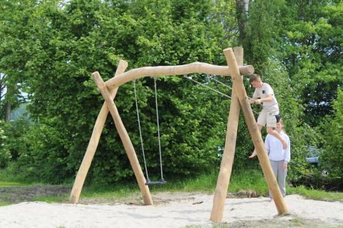 a man on a swing set in the sand at Camping de Betovering in Zeewolde