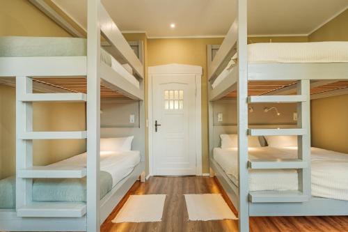 two bunk beds in a room with wood floors at Rhein Haven Appartment für bis zu 12 Gäste im historischen Bahnhofsgebäude in Frechen