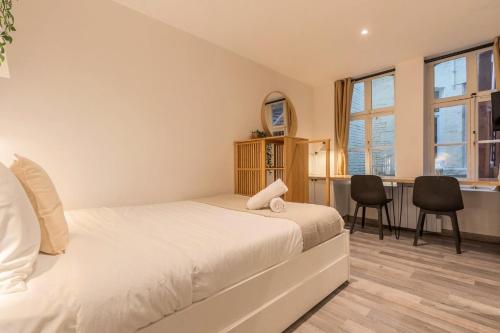 - une chambre avec un lit et un bureau avec des chaises dans l'établissement Lille Grand-place : Functional and quiet studio !, à Lille