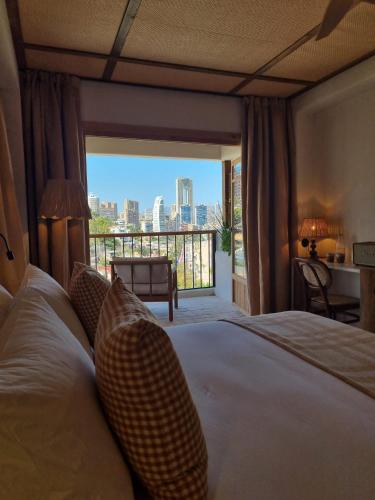 a bedroom with a bed with a view of a city at Nomad Boutique Resort Benidorm in Benidorm