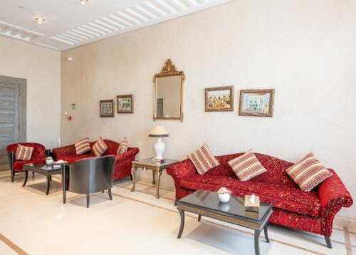 a living room with red couches and a mirror at Pickalbatros Hôtel Du Golf - Adults Friendly 16 Years Plus- All-Inclusive in Marrakech