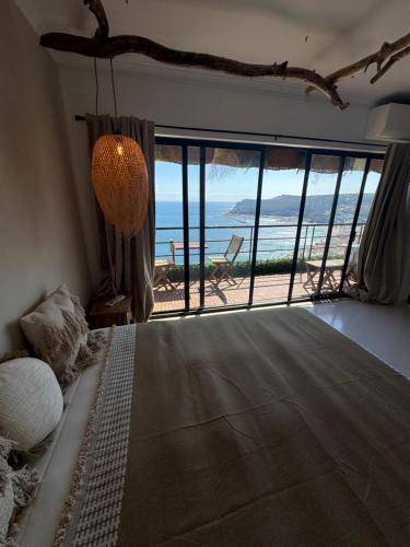 Un dormitorio con un gran ventanal con vistas a la playa. en Comfort Viewpoint Sesimbra - parking at center, en Sesimbra