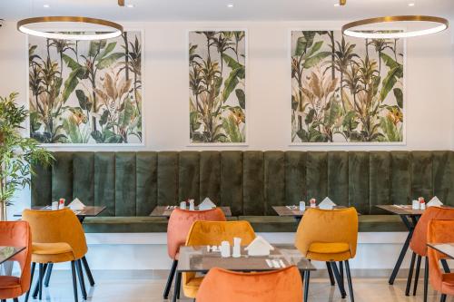 a dining room with tables and chairs and paintings on the walls at Philia Center Suites in Rhodes Town