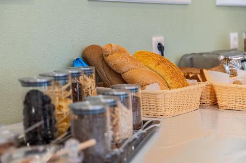 a table with baskets of bread and jars of food at Philia Center Suites in Rhodes Town