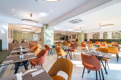 a restaurant with tables and chairs and a cafeteria at Philia Center Suites in Rhodes Town