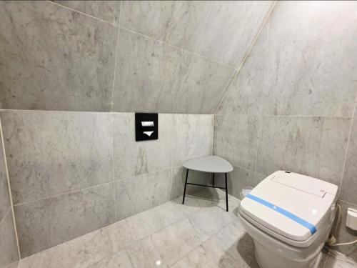 a bathroom with a toilet and a stool in it at Blueduck hotel in Seoul